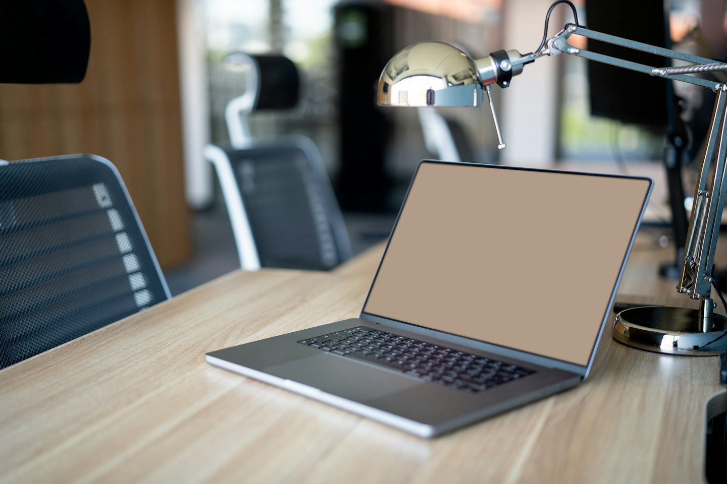 Un moderno computer portatile su una scrivania di legno chiaro.
