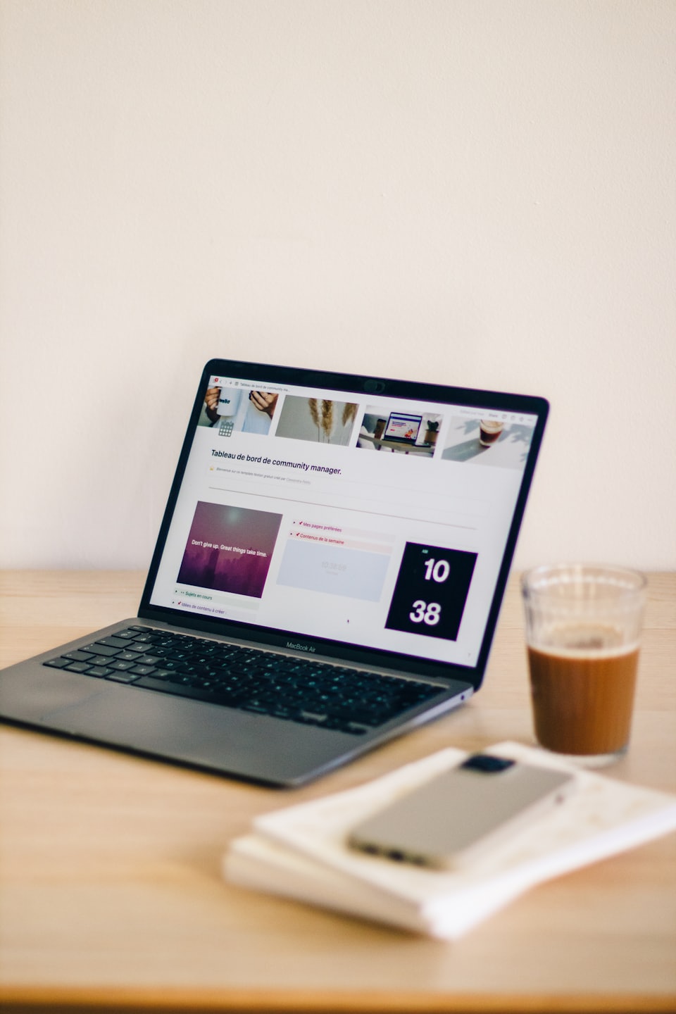 Laptop con dashboard su una scrivania di legno con caffè freddo.
